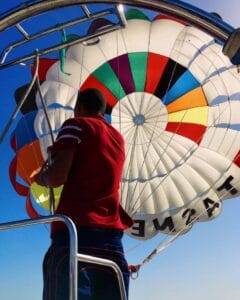 A man on a boat releasing a parasail parachute into the air | Fly-n-Float Thailand